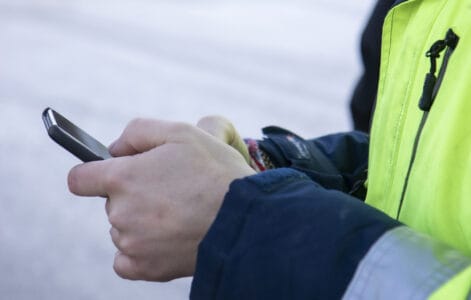 Person som håller i mobiltelefon.