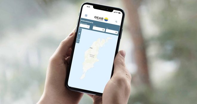 Hand som håller i telefon med Geabs avbrottskarta.