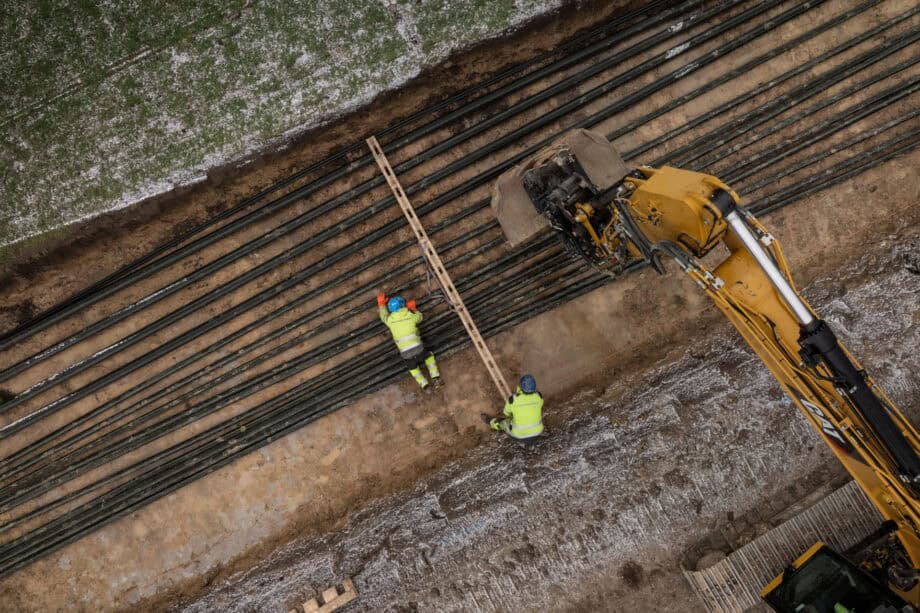 Två personer lägger kabel i mark