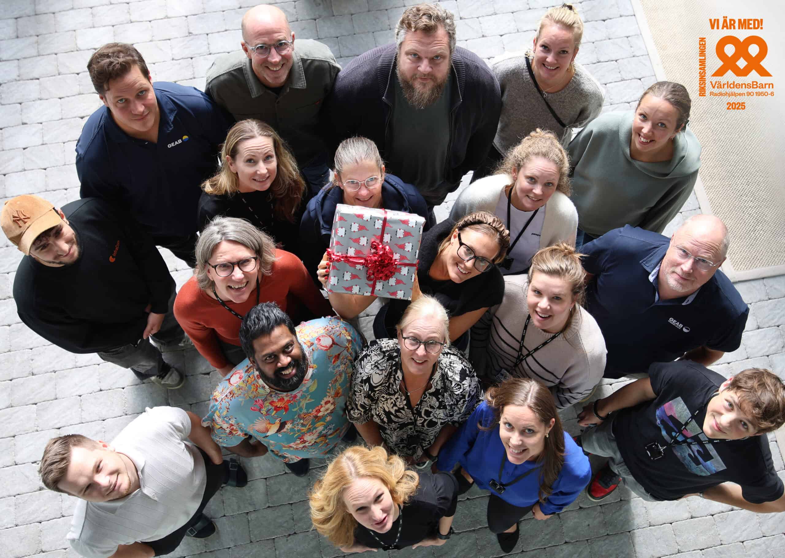 Flera medarbetare håller upp en julklapp