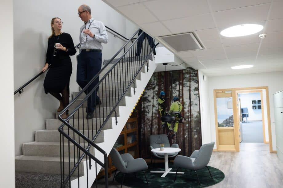 Två medarbetare går nerför en trappa på kontoret.