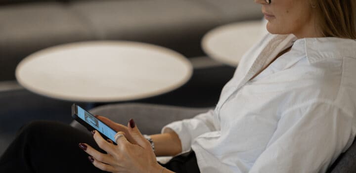 Medarbetare håller mobiltelefon i handen