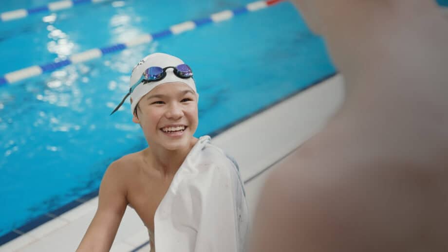 Pojke vid poolkant ler