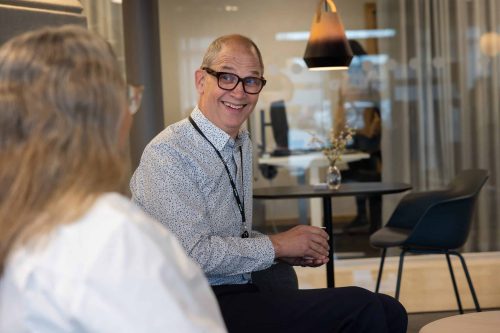 Medarbetare som sitter i receptionen till kontoret.