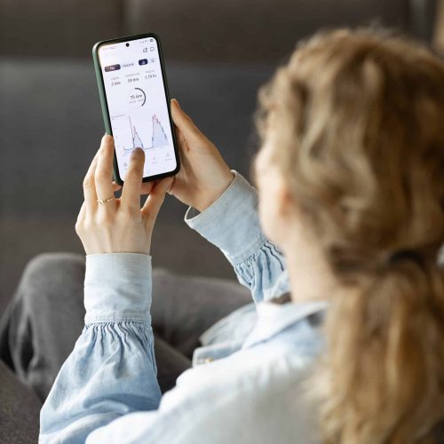 Medarbetare håller mobiltelefon i handen