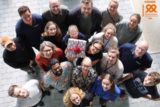 Flera medarbetare håller upp en julklapp